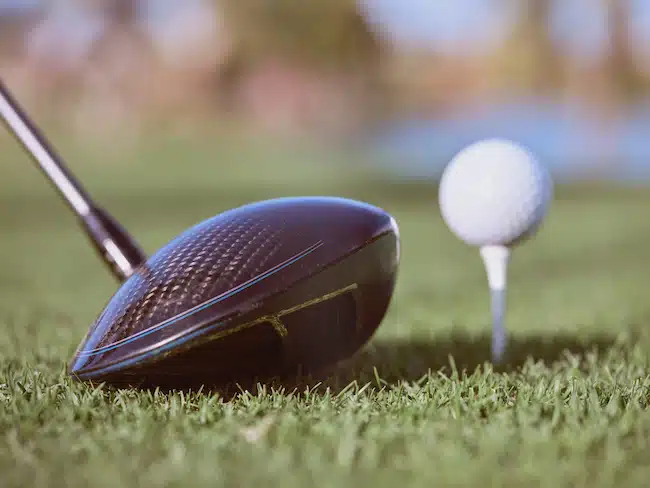 Golf club driver near ball on grass