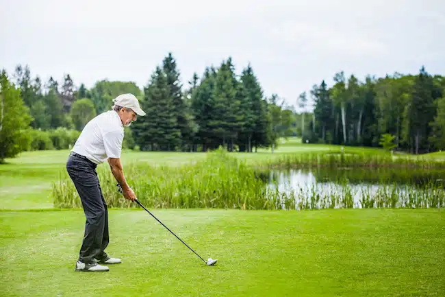 Mature golfer driving on golf course